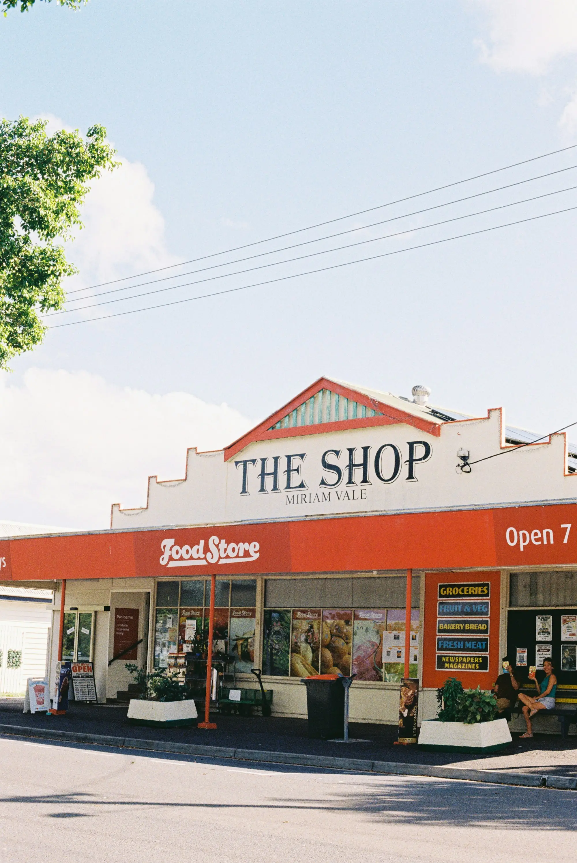 Country-town shopfront with a heritage parapet under a bright blue sky, the kind of commercial property used as loan security