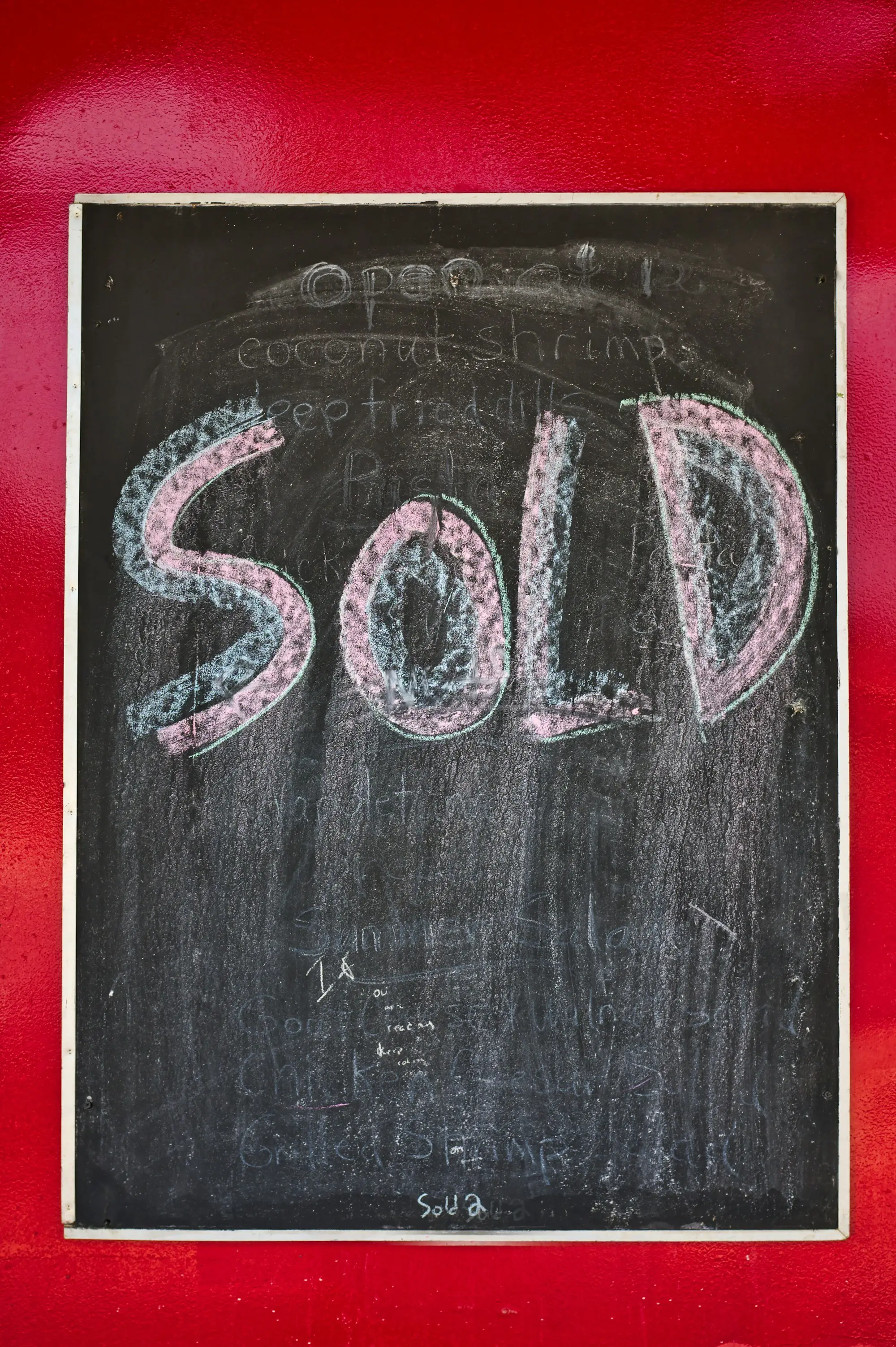 The word sold chalked on a board, marking a property sale that will repay a bridging loan