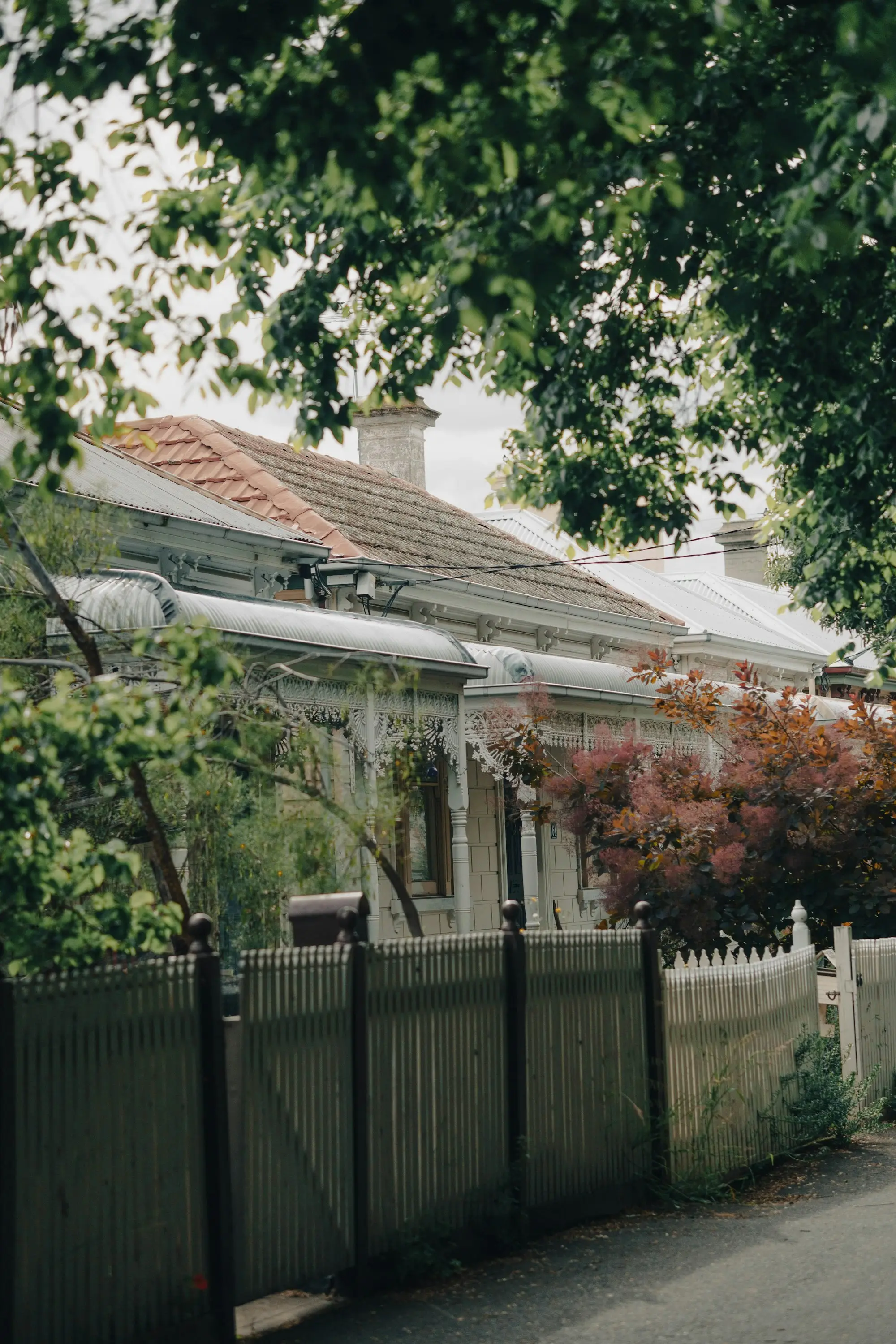 Victorian-era terrace house with iron lacework and a front fence on a Melbourne street